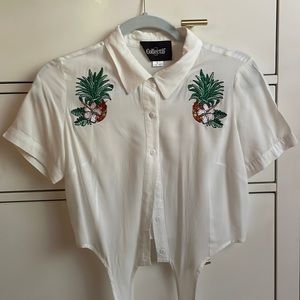 White crop button down shirt with pineapple orchid detail.